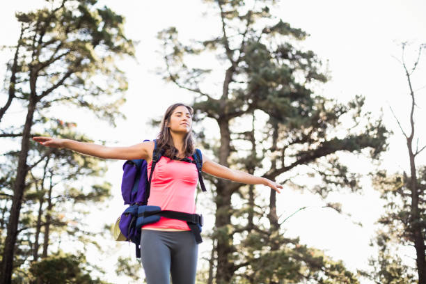 istock Young happy jogger standing on rock feeling free 669009568