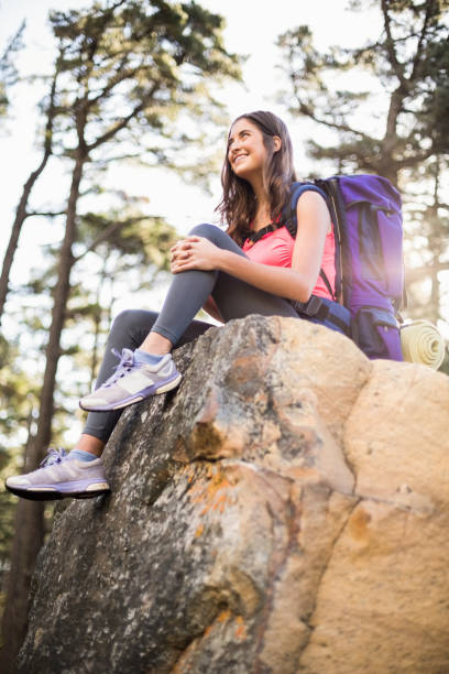 istock Young happy jogger sitting on rock and looking away 669009898