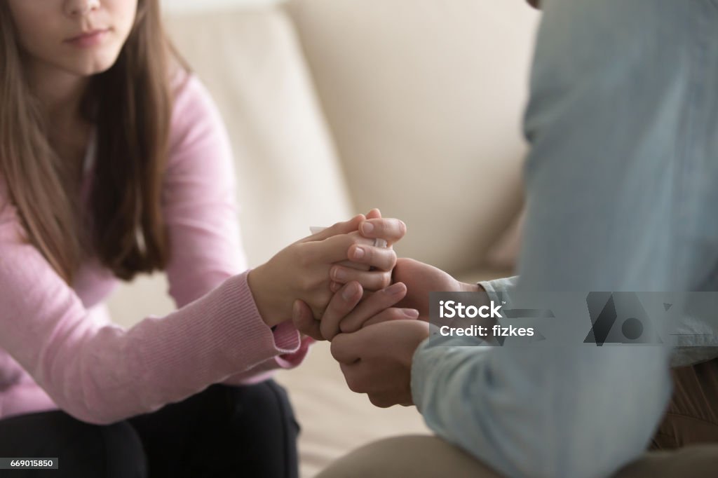 Closeup of man holding crying woman hands, compassion and comfort Close up view of upset couple, guy holding hands of crying woman, trying to comfort and console her, boyfriend apologizing offended lady, asking for forgiveness. Support, regret and compassion Consoling Stock Photo