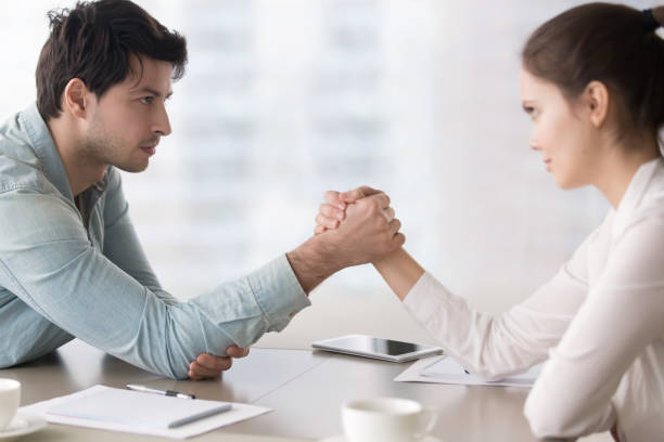 mujeres y hombres de negocios rivales para el armrestling, compitiendo por el liderazgo, derechos - conflict competition arm wrestling business fotografías e imágenes de stock