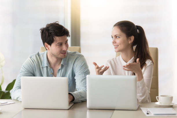 istock Conversation between two colleagues or business partners sitting with laptops 669016026