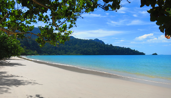 Beautiful white sands beach with crystal clear blue turquoise waters on the tropical island Langkawi, Malaysia on a sunny, warm day