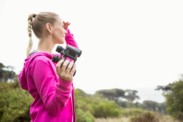 istock Female hiker looking away and holding binoculars 669032184