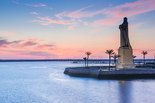 Discovery Faith Christopher Columbus Monument in Palos de Frontera, Spain at blue hour after sunset with palms silhouettes