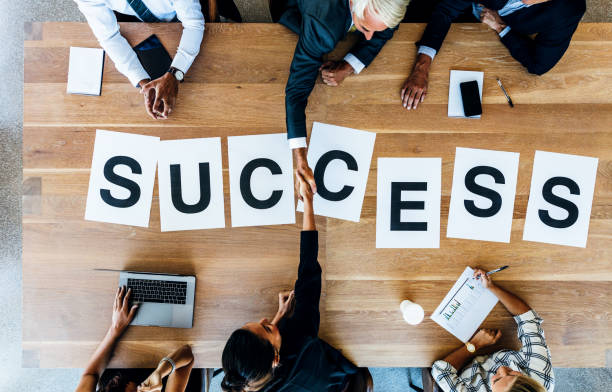 istock Businesspeople handshake with word success on table 669040700