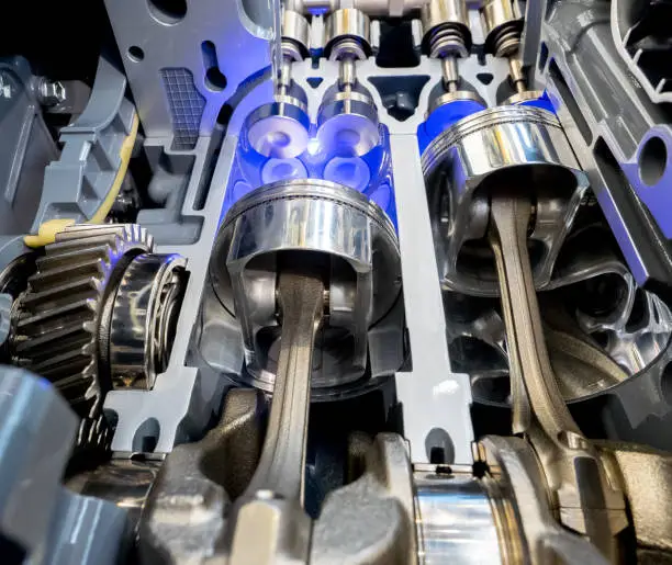 Inside view of engine, close up detail of two pistons in cylinder with four valves,some gears aside.