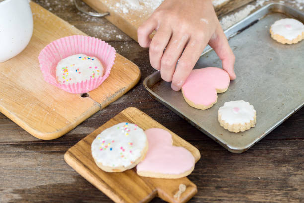 istock Hand take heart shaped cookie from baking trey 669044140