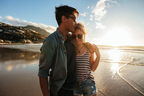 istock Romantic young couple standing together on beach 669044176