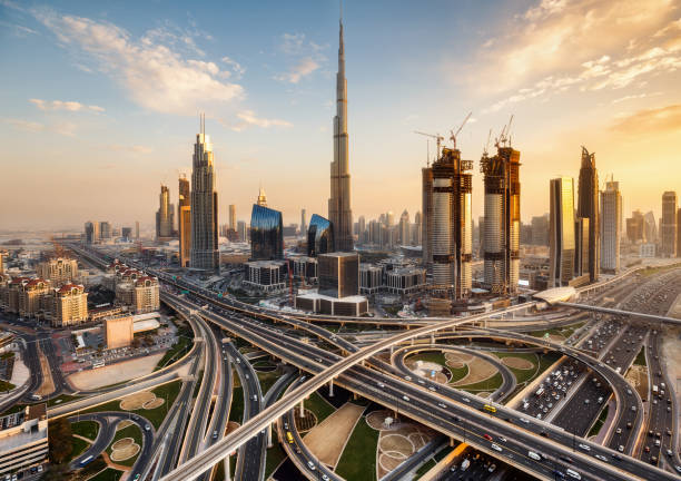 Spectacular skyline of Dubai, UAE.  Futuristic modern architecture of a big city at sunset with a large highway intersection. Spectacular skyline of Dubai, UAE.  Futuristic modern architecture of a big city at sunset. Aerial view. west asia stock pictures, royalty-free photos & images