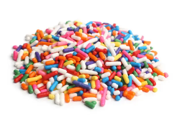 Assorted colored sprinkles on white background