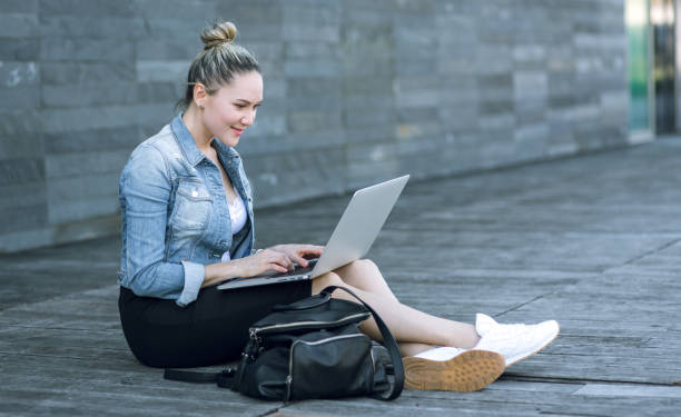 istock Woman using laptop outdoors 669057898
