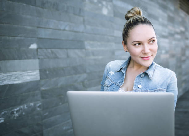 istock Woman using laptop outdoors 669057924