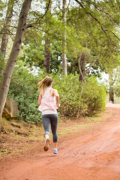 hübsche blondine sportler joggen - running jogging footpath cross country running stock-fotos und bilder
