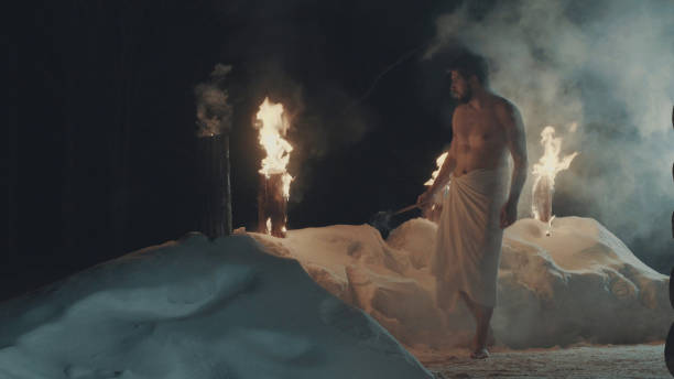 istock Man after sauna, in a towel barefoot on the snow. 669068192