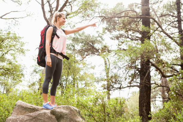 istock Smiling blonde hiker pointing far away 669068472