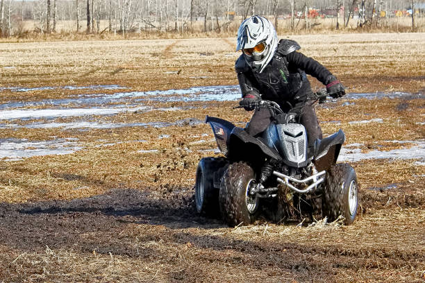istock Youth doing donuts in the mud on his quad 669068804