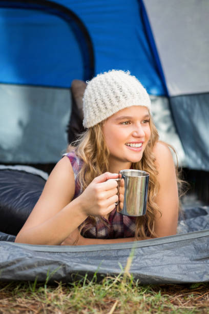 istock Pretty blonde camper smiling and lying in tent 669082302