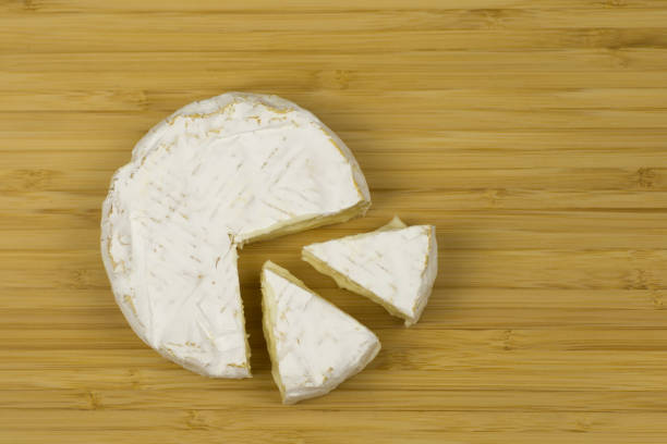 istock Brie cheese and a slice on a wooden board. 669084866