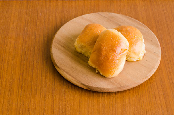 frais fait maison, cuisson du pain brioche beurre délicieux sur plateau en bois sur fond de plancher en bois de teck brun avec la lumière du soleil sur le côté d’hôtes heureux avec espace copie - brown bread bread wheat bakery photos et images de collection