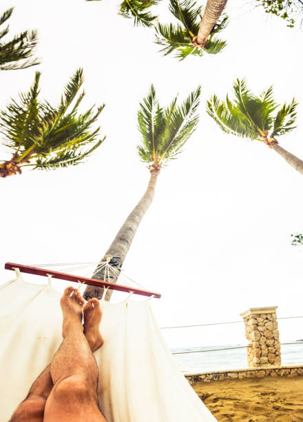 istock Man relaxing in a hammock by the beach POV 669097596