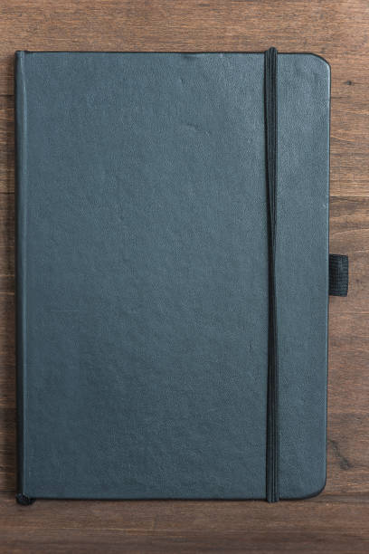 istock closed black copybook on wooden background 669100820