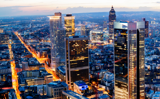 Frankfurt skyline illuminated at dusk, financial district, Germany, long exposure with tripod, 50 megapixel image, horizontally stitched composition.