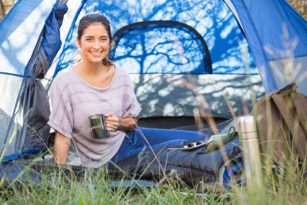 istock Smiling brunette camper sitting in tent 669101424