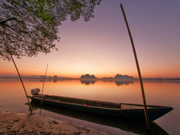 istock Long tail boat on river side in front of amazing sunset 669105934