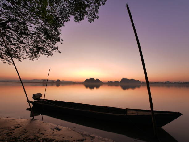 istock Long tail boat on river side in front of amazing sunset 669105936