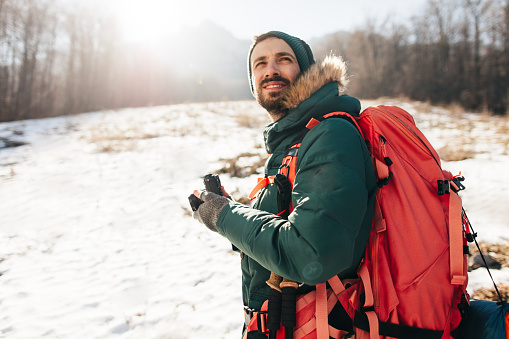 Young, smiling photographer exploring nature and making photos with his camera