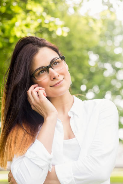 istock Beautiful brunette making a call in the park 669115492