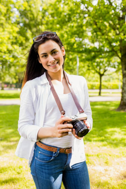 istock Beautiful brunette taking photo in the park 669122020