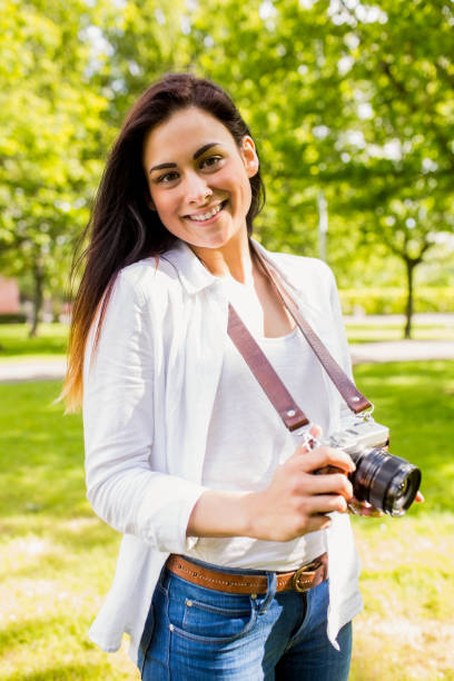 istock Beautiful brunette taking photo in the park 669122046