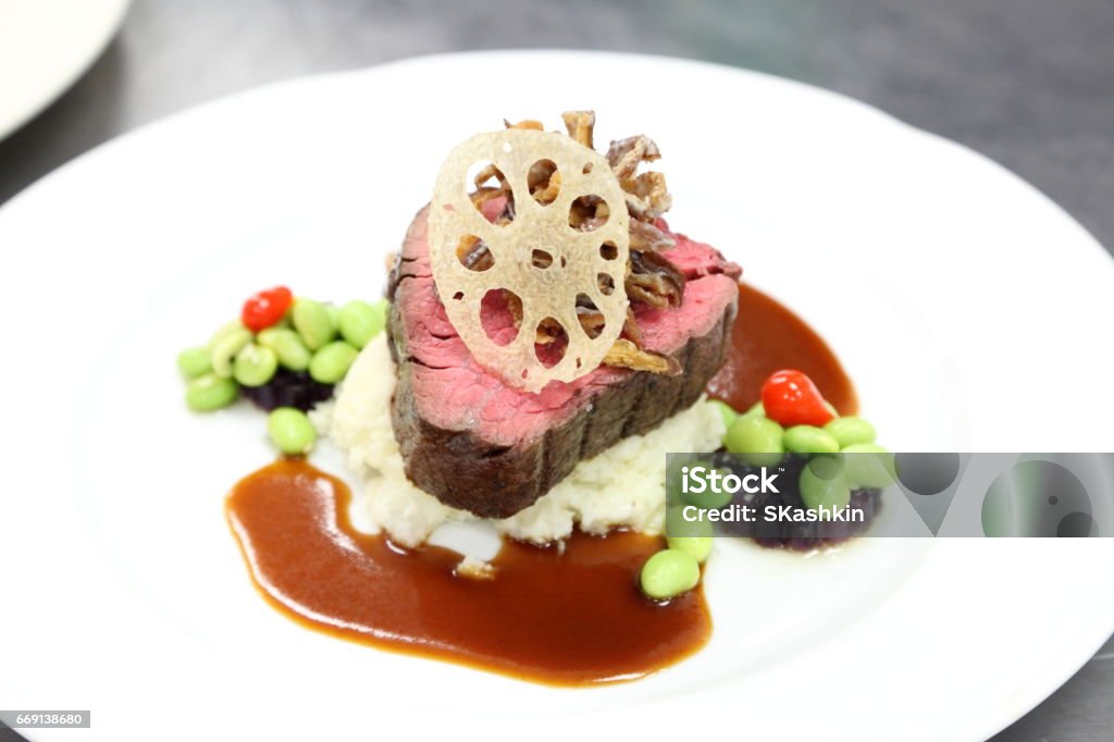 Kobe beef tenderloin, wasabi mashed potato, edamame sauce, lotus root chip. Kobe beef tenderloin, wasabi mashed potato, edamame sauce, lotus root chip. Horizontal. Beef Stock Photo