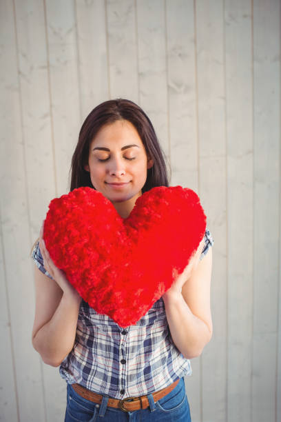 istock Pretty hipster holding heart pillow 669138782