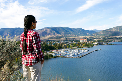 Tourist looking at the city of Penticton and Okanagan Lake from Munson Mountain Park in Penticton, British Columbia, Canada. Penticton is a city located in the Okanagan Valley.