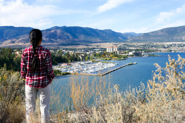 Tourist looking at the city of Penticton and Okanagan Lake from Munson Mountain Park in Penticton, British Columbia, Canada. Penticton is a city located in the Okanagan Valley.