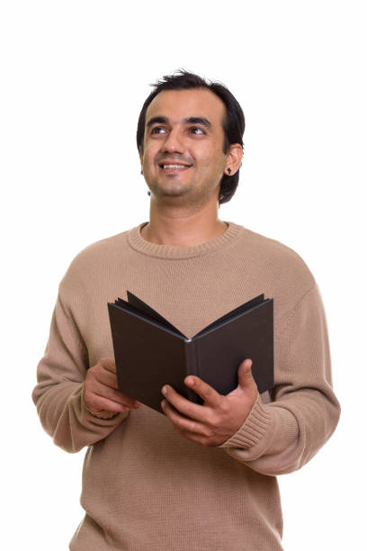 istock Studio shot of happy Persian man smiling while holding book and thinking 669176972