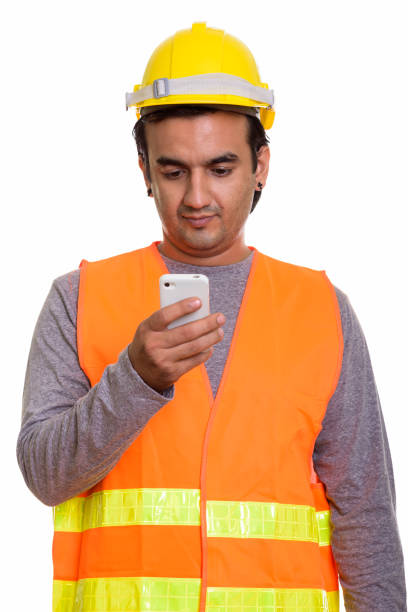istock Studio shot of Persian man construction worker using mobile phone 669177196