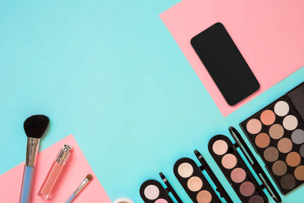 istock Make up essentials. Set of professional make up brushes, creams and shadows in jars on blue background 669180558