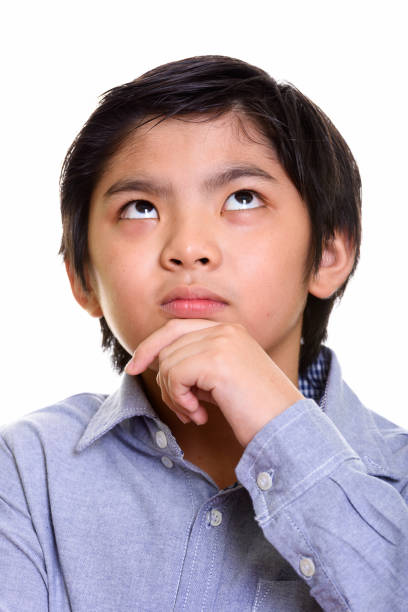 istock Face of cute Japanese boy thinking while looking up 669184962