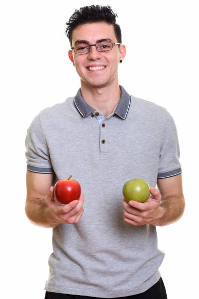 istock Studio shot of happy young man smiling while holding red apple and green apple 669187814