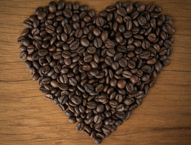 istock Heart-shaped coffee beans on old wooden boards 669196730