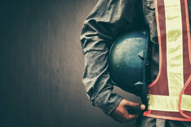 mann hält blauhelm aus nächster nähe - construction worker hardhat safety manual worker stock-fotos und bilder