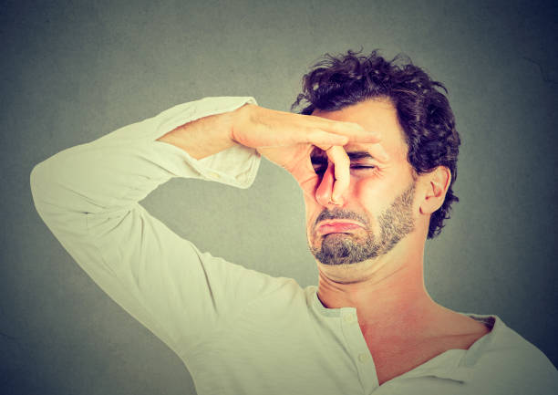 istock young man with disgust on his face pinches nose, something stinks 669213148