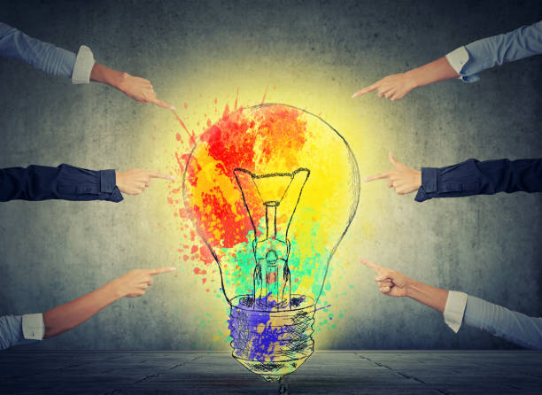 istock Human arms fingers point at bright idea colorful glowing light bulb 669214246