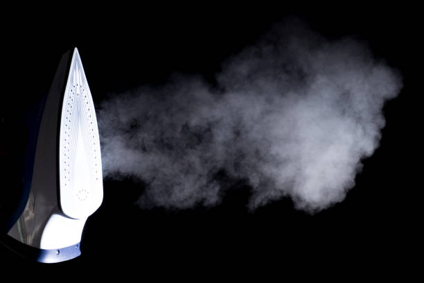 istock iron  blowing off steam on black background 669217612