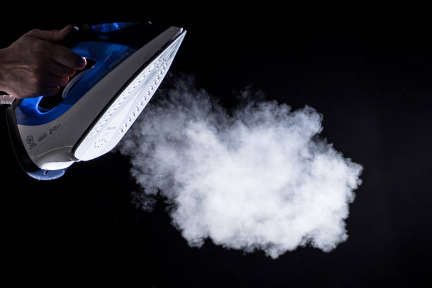 istock iron  blowing off steam on black background 669217658