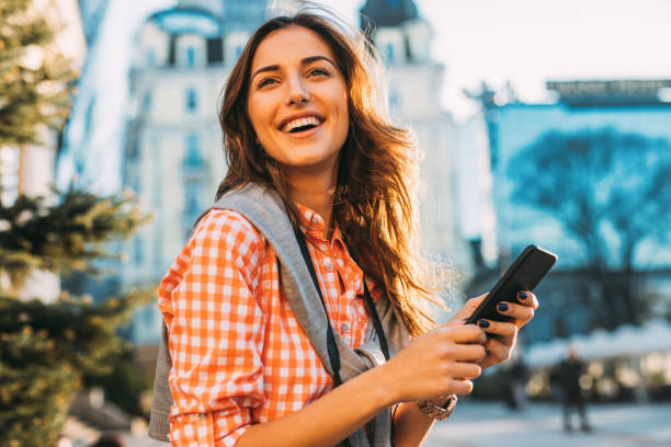 istock Beautiful woman texting outdoors 669220280