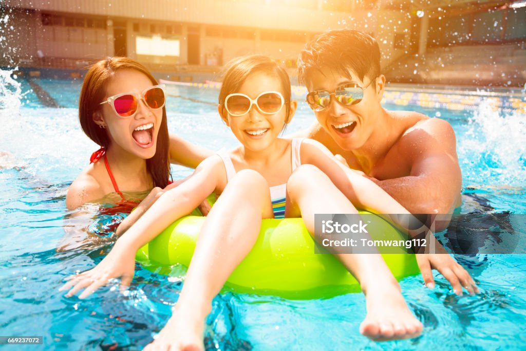 Familia feliz jugando en la piscina - Foto de stock de Familia libre de derechos